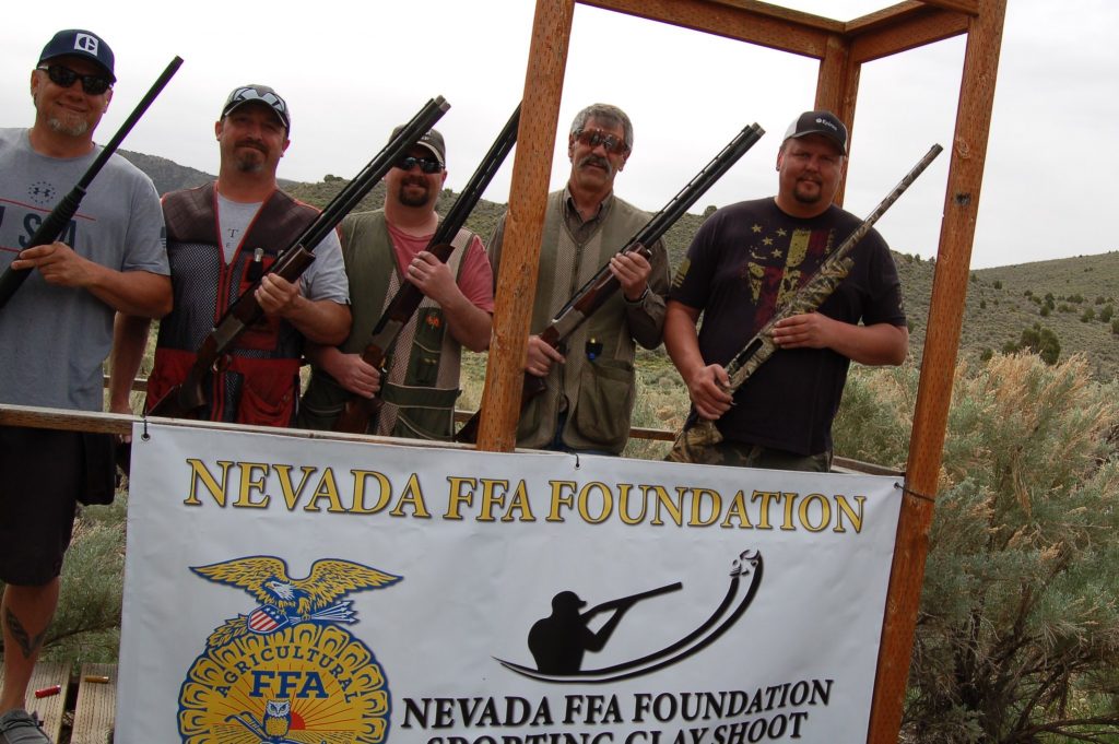 A group of men pose holding shotguns
