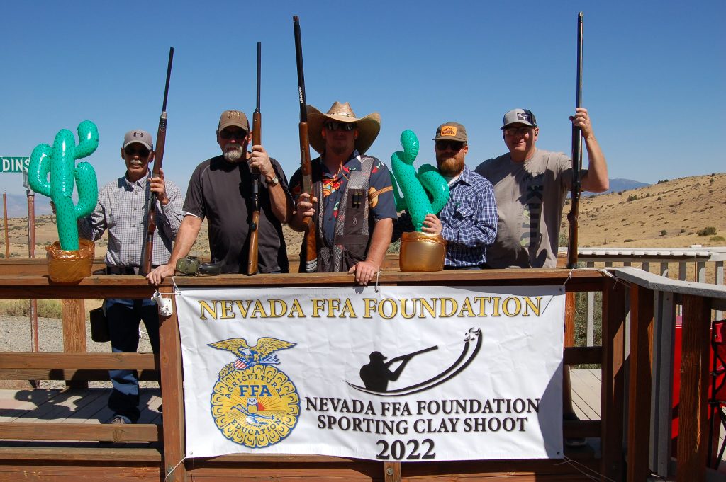 Men post hold shot guns with a Nevada FFA Foundation sign in front of them